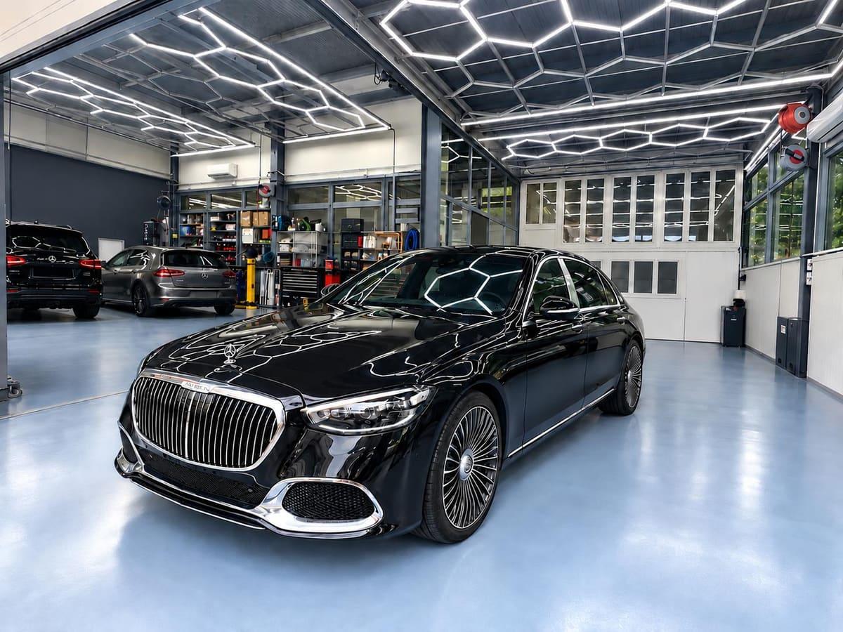 Berline noire dans le grand hall lumineux de Carrosserie Pista