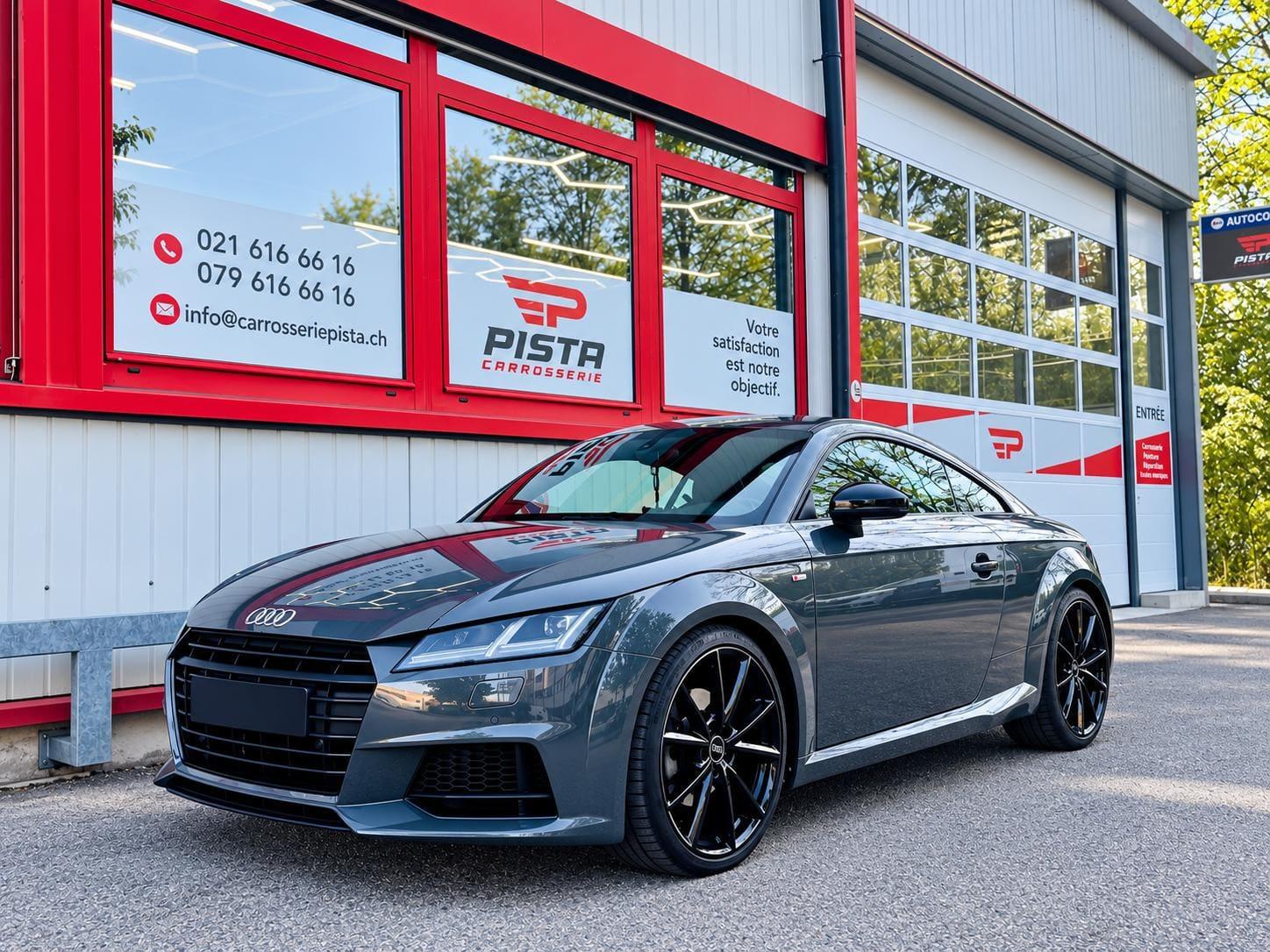 Coupé sportif gris devant l'atelier de Carrosserie Pista