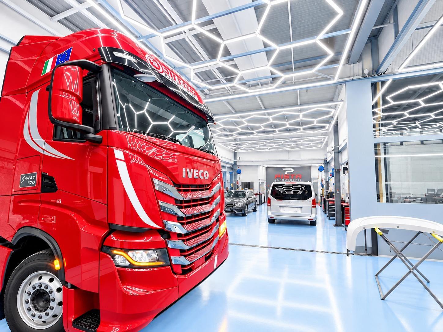 Camion rouge dans l'atelier de Carrosserie Pista sous l'éclairage hexagonal