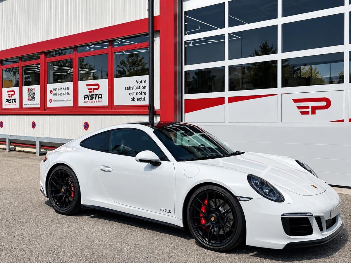 Coupé sportif blanc à la carrosserie impeccable devant l'atelier de Carrosserie Pista